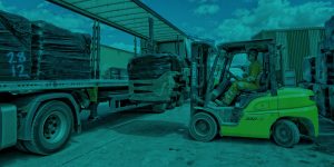 Countrystyle image of fork truck loading bails onto truck.